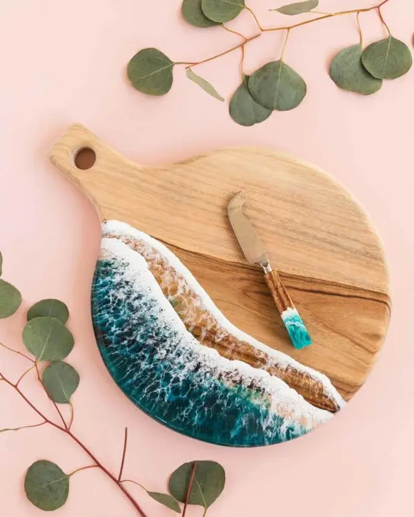 Ocean, River Inspired Charcuterie Board and Knife Set on pink background with eucalyptus leaves